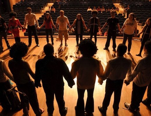 persone in circolo che si danno la mano