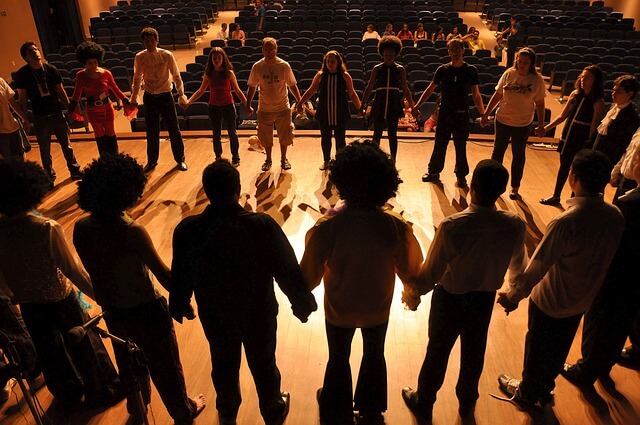 persone in circolo che si danno la mano